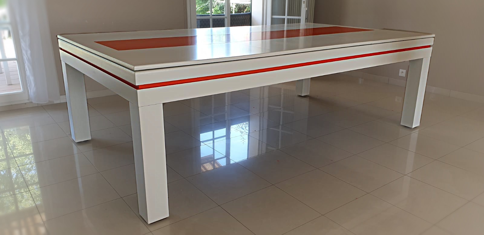 Billard transformé en table design à deux couleur. Le cadre blanc est souligné d'un liseré orange, tandis que le plateau blanc est habillé d'un décor centrale orange.